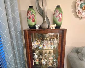 Curio with glass shelves full of vintage collectibles