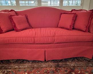 Skirted chippendale camelback sofa with four matching pillows.