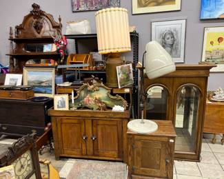 A repro "ICE BOX" / end table made of oak, on top a 1950's salon hair dryer, behind it a nice display cabinet, and misc. art on walls...