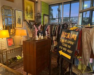 THIS PALCE IS FULL OF CLOTHES, COLLECTIBLES AND VINTAGE FURNITURE! BEHIND AGAINST THE WALL TO THE LEFT ARE TWO OUT OF THREE PIECES OF A "HOLLYWOOD REGENCY" SUITE. 1) CONSOLE 2) FRAMED BEVELED MIRROR 3) (PICTURED ON ANOTHER SLIDE) A SHELVED ETAGERE. ALL THREE ARE IRON GOLD GILT IN BAMBOO DESIGN WITH BEVELED GLASS & MIRROR -- ABSOLUTELY FABULOUS!