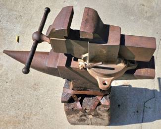 Big vintage Prentiss Bulldog (New York) bench vise. Large, heavy vintage anvil strapped on an old block of wood.