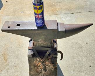 Large, heavy vintage anvil strapped on an old block of wood.