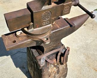 Big vintage Prentiss Bulldog (New York) bench vise. Large, heavy vintage anvil strapped on an old block of wood.