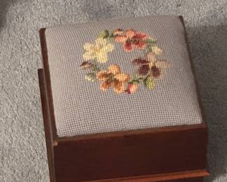 This is an adorable small, maybe 9”x9”, small stool with needle point cover. 