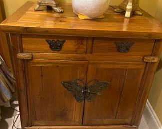 $320. Vintage two drawer one door wood side table with butterfly handles. Dimensions are 31 inches wide by 21.5 inches deep by 31 inches high.   Available for online purchase per the instructions on the sale details page, pickup is during in-person shopping hours.