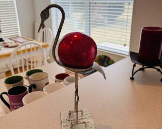 Skinny bird carrying a bowling ball.  