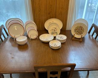 Nice wide shot of the dining room table and chairs! (4 chairs 2 captains) ON it are three sets of vintage dishes! 