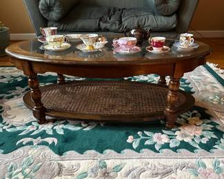 C43- $50.  Unmarked Oval Wooden and Caned Coffee Table.  Measures 46" long x 24" deep x 16.5" tall. 