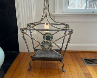 C23- $150.  Maitland Smith Magazine Rack with Iron Cord Design. Heavy Metal Frame! Has glass behind the lion heads. Measures 17" wide x 9.5" d x 26" tall. 