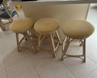 3 shorter bar stools covered in light yellow fabric