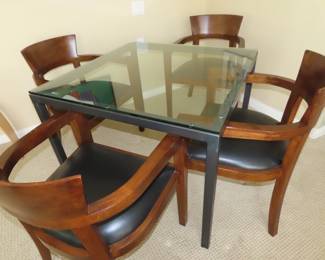 Four chairs and glass and metal table.