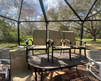 Wrought iron oval table (83" x 49") with umbrella and 4 chairs.