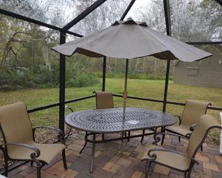 Wrought iron oval table (83" x 49") with umbrella and 4 chairs.