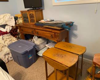 Pair of end tables. Sofa table. Piles of linens. 