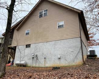 View of rear of house. Large propane tank. 
