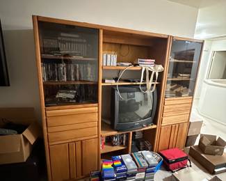Entertainment center is filled with dvds, cds, and all kinds of VHS