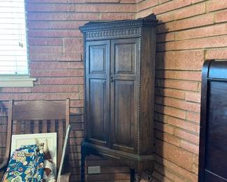 Petite corner cabinet. Rocking chair under fabric
