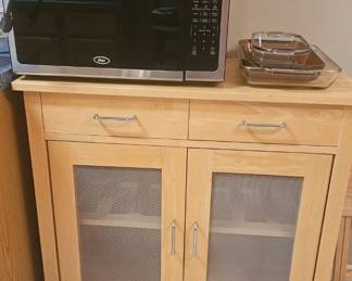 Microwave, kitchen cart, and miscellaneous kitchen items.