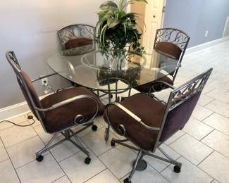 Glass top table with 4 eggplant chairs on wheels