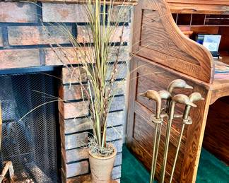 Dry grass in clay vase and wonderful brass Duck head fire place tools