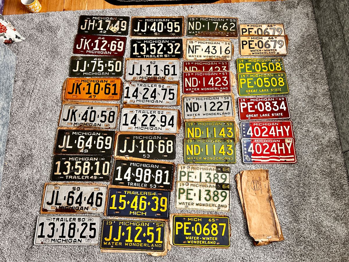 Great selection of vintage Michigan license plates, some with their original paper envelopes 