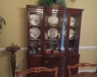 Beautiful wood China cabinet filled with serving pieces.