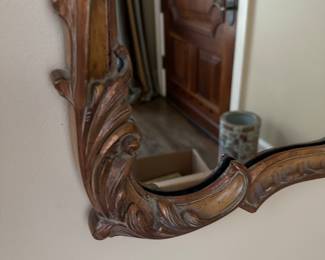 close up of the carved detailing on the mirror's frame