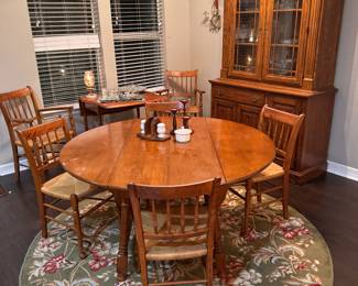 Round solid wood table.  Drop leaf sides.   Two arm chairs and four side chairs. 