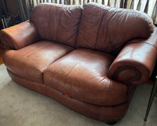 Leather loveseat with nail head trim.