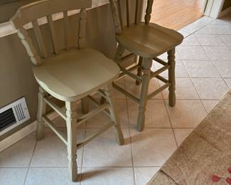 Bar stools with large frameless mirror behind them. 