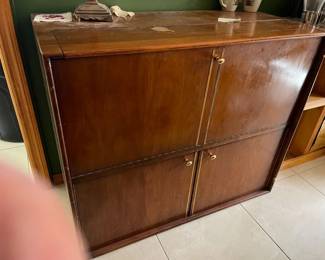 This is unusual piece on the bottom is a cabinet that opens up on the top is a door that pulls down and the drawer moves out when you pull the top down very interesting. Unique would be a great bar.