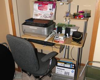 Multi-tiered office desk with office supplies and and office desk