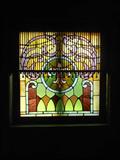 Stained Glass with Fretwork hanging in front of glass item