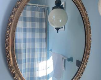 Gold oval mirror and midcentury hanging lamp