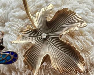 Classic 14 karat leaf pin set with small diamond accent. 