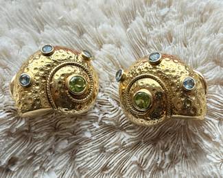 A textured pair of 18k yellow gold aqua and peridot shell style omega back earrings. 