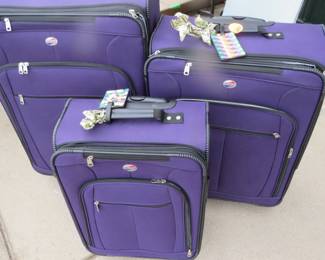 Lot 198. Three purple American Tourister suitcases