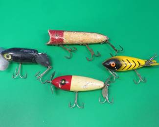 Lot 473. Four vintage lures: Arbogast jointed Jitterbug, Heddon Lucky 13, Bomber Unidentified 2 7/8" wooden South Bend Surf-Oreno style with tack eyes.