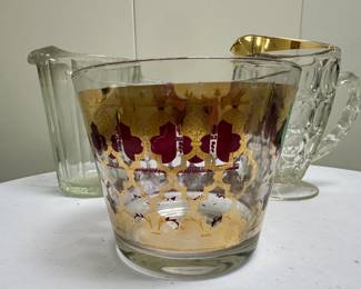 (3pc) Mid-Century Pitchers | Miscellaneous mid-century glassware including: Ice bucket: dia. 6 in.
Glass pitcher with gold-trimmed lip
Glass pitcher with pleated sides - h. 7 in (pitcher)


