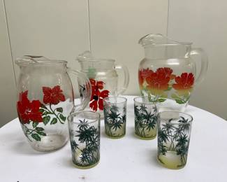 (7pc) "Tropical" Motif Glassware |  Glassware with "tropical" (palm trees, florals, etc.) motifs including: Three pitchers with red/orange flower motifs
Four drinking glasses with palm tree motifs