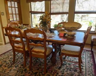 Matching distressed, pine dining table with one leaf and six chairs and area rug