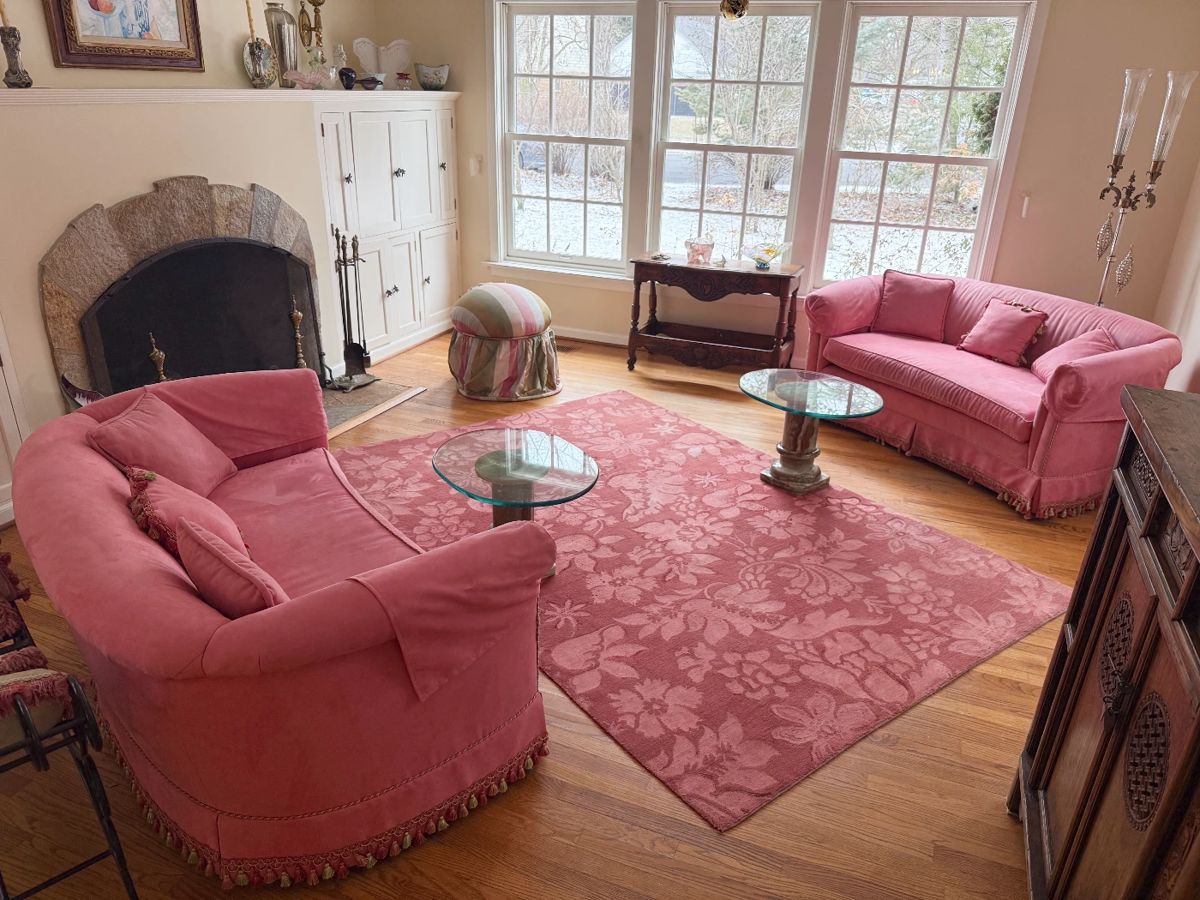 Pair of microsuede love seats, floral rug, and a pair of glass top alabaster pedestal coffee or side tables