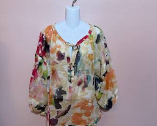 Diane von Furstenberg silk floral print blouse, size 8, with beaded tie at V neck and 3-button closure at front. Cuffs with single-button closure and ruching. 3/4 dolman sleeves.