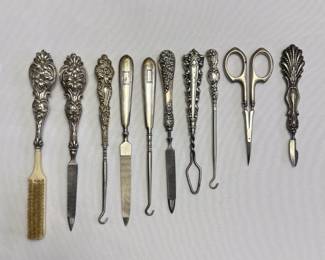 Sterling silver handled button hooks, nail files, scissors and brushes