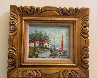 Signed small oil painting of boats near a shore with houses at water's edge, carved wooden frame