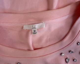 Closeup of Joh pink puff sleeve t-shirt with rhinestone decoration on shoulders