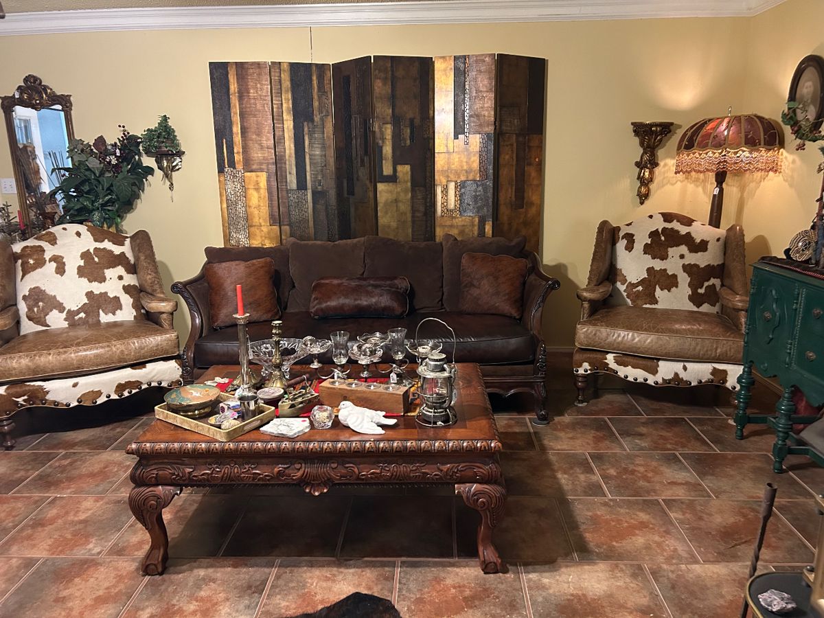 Beautiful leather couch, pair of Cowhide chairs, ornate coffee table ( matches end tables & entry table), floor la mop with  embellished shade, 6 panel room divider, solid brass elephant head shelf