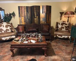 Beautiful leather couch, pair of Cowhide chairs, ornate coffee table ( matches end tables & entry table), floor la mop with  embellished shade, 6 panel room divider, solid brass elephant head shelf