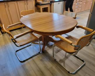 Vintage solid oak pedestal table with one leaf. Four vintage 80's Breuer/Cesca chairs. Excellent condition.