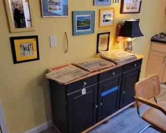 Various wall decor, black and pine cabinet, lamp.